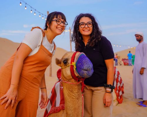 girl posing with camel in desert